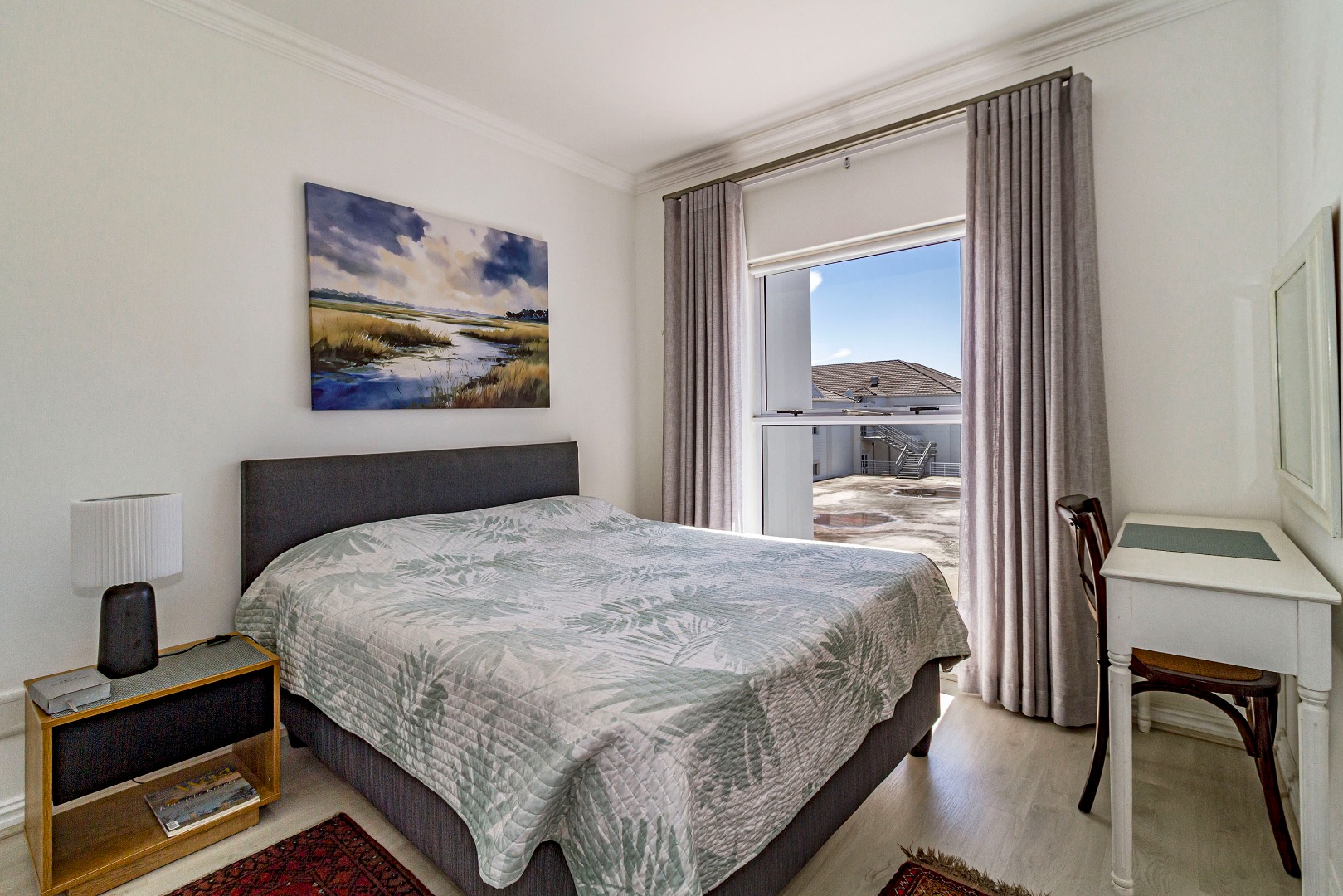 Sunny master bedroom with built in cupboards